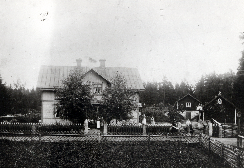 Framför  Ekebydals handelsbod  sitter troligen familjen  Österberg . Kvinnan i förkläde är ev barnen Österbergs moster Tekla Eriksson . Kvinnan mellan  hästkärran  och  hästen  t h i vit sjal är  Edla Lutteman  Kragsta.  Mjölkbrygga  fanns vid vägskälet.  Ekebydal byggdes av handlaren  Conrad Österberg   Uppgifter från Conrad Österbergs dotter Signe Gustafsson