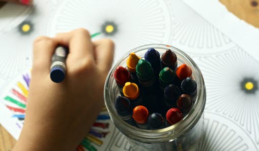 Barn som riter med kritpennor i olika färger.