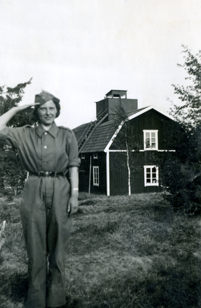 Gullan Laurell som luftbevakningslotta vid arrendatorsbostaden vid Frösunda prästgård. Två lottor arbetade samtidigt under tio dagar och sov på madrasser på golvet. Notera bevakningstornet på husets tak där lottorna observerade luftrummet . Chef för lottorna var Signe Andersson, Anne-Marie Thorsaeus var vice chef och övriga lottor meniga. De som arbetade med luftbevakning kallades tornsvalor.