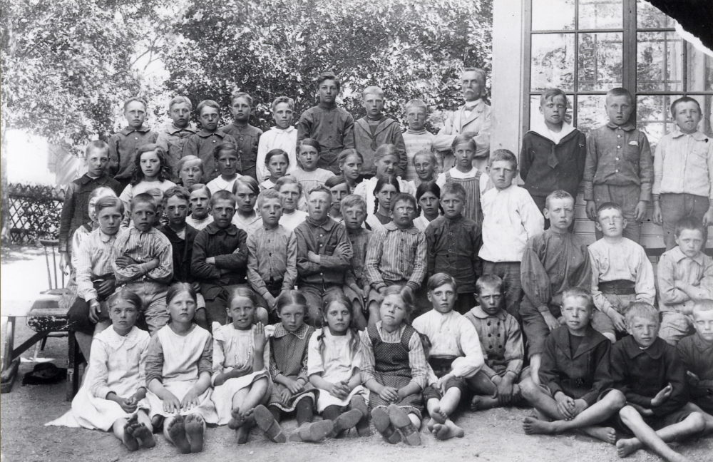 Läraren Zackeus Carlsson-Waldebäck tillsammans med skolbarnen utanför Frösunda kyrkskola