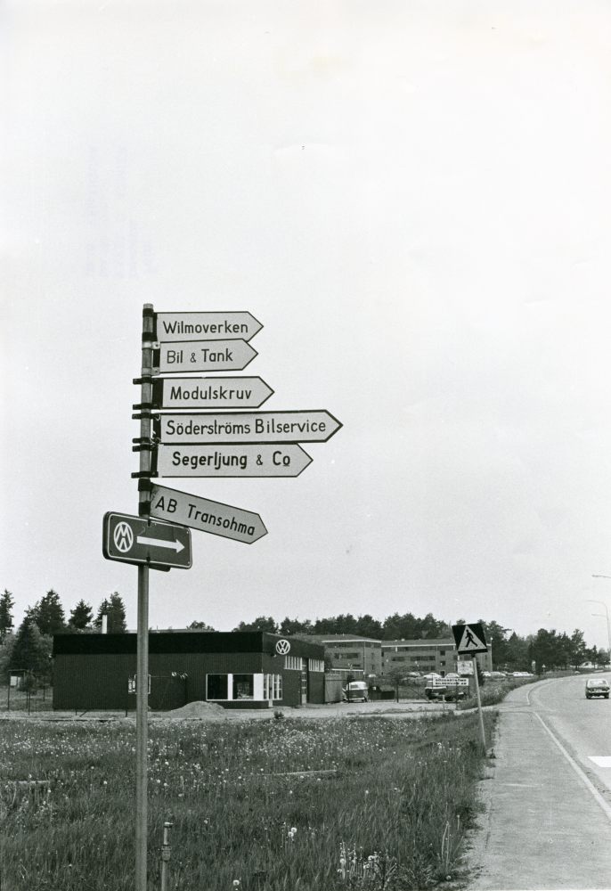 En vägvisare vid Mörby industriområde visar pilar mot Wilmoverken, Bil & Tank, Modulskruv, Söderströms Billservice, Segerljung & Co, AB Transohma.
•Fotografiet ingår i bildserien ”Vardagsliv i Vallentuna kommun” av Rachael Gough-Azmier & Gunilla Blomé, Haga Studios HB.