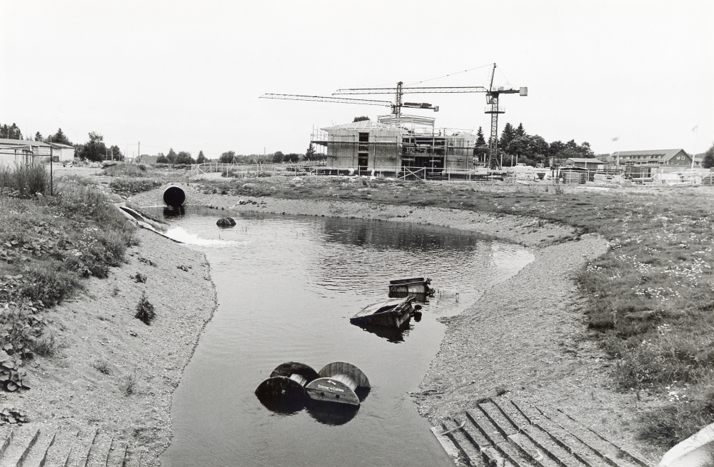 Vatten från Vallentuna värmeverk rinner ut i Ormstaån.  Vattnet kommer från uppvärmt sjövatten i ledningar i Vallentunasjöns lera och rinner avkylt tillbaka via Ormstaån.  I bildens mitt syns Vallentuna sjukhem och läkarstation under byggnad