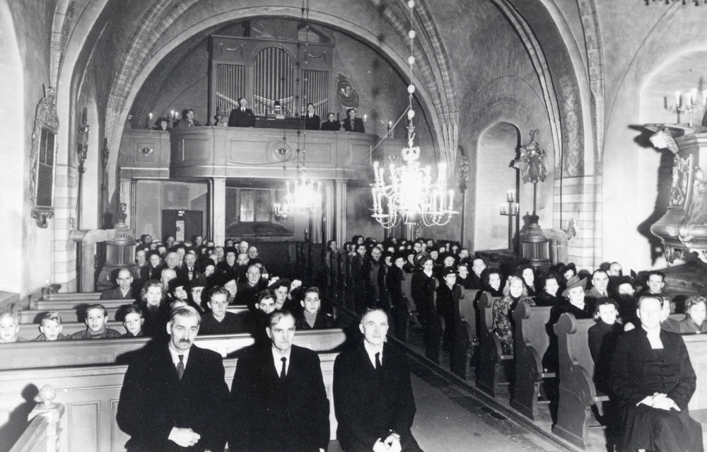 Nyårsbön i Frösunda kyrka.  På första bänk sitter fr v kyrkvärdrna Henning Larsson och Fritz Andersson samt kyrkvaktare Joh Eriksson, t h sitter kyrkoherde Östen Hårdh