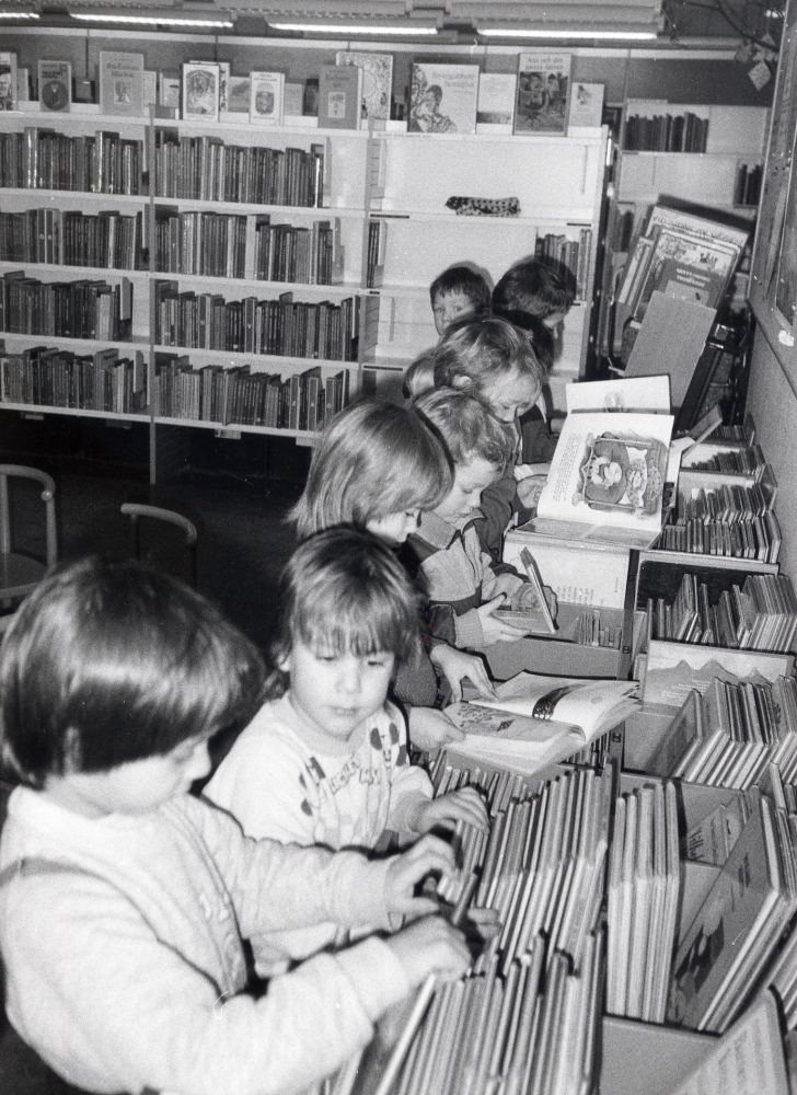 En grupp barn från Granåsa daghem besöker Vallentuna bibliotek. Här tittar barnen bland bilderböckerna på barnavdelningen