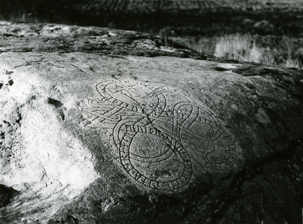 Runhäll med beteckningen U210 i Åsta, cirka 225 meter väster om gården och strax norr om landsvägen Angarn - Vallentuna centrum vid en busshållplats.