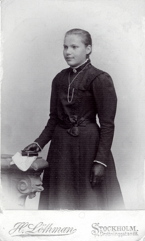 Signe Eleonora Johansson från Helgö gård  vid konfirmationen i Frösunda kyrka.  I samband med modern Lina Johanssons giftermål med A V Eneroth 1905, flyttade Signe till Uthamra gård i Vallentuna.  Signe gifte sig 1919 med Birger Åkerberg, Vivelsta i Markim