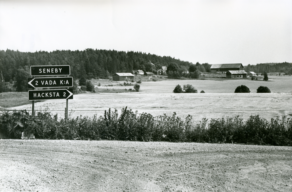 Vägskäl vid Seneby med vägskyltar / vägvisare, Seneby, 2 Vada k:a, Hacksta 2.
•Fotografiet ingår i bildserien ”Vardagsliv i Vallentuna kommun” av Rachael Gough-Azmier & Gunilla Blomé, Haga Studios HB.