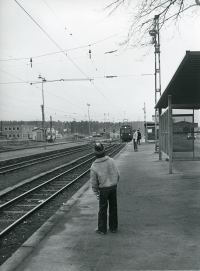 En pojke står på perrongen vid Vallentuna station och tittar på tåget som är på ingång från Stockholm.