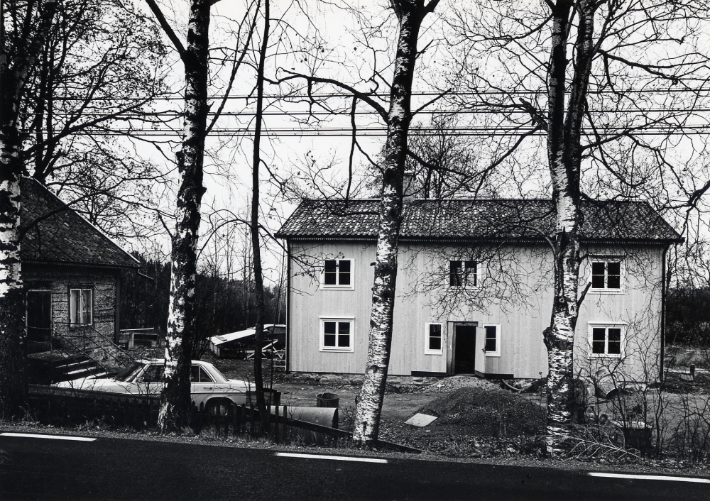 Åbyholms gård innehade gästgiveri och skjutsstation från slutet av 1700-talet till 1885, då järnvägen Stockholm-Rimbo invigdes och gästegiveriet flyttade till Vallentuna järnvägshotell. I gården har även hållits ting. I en av gårdens flyglar har det funnits en handelsbod 1977 köptes gården av Anders Fröderberg och har omsorgsfullt restaurerats. På bilden ses gården från Åbyholmsvägen med huvudbyggnaden under restaureringsarbetet och den södra flygeln t v där arbetet ännu bara påbörjats