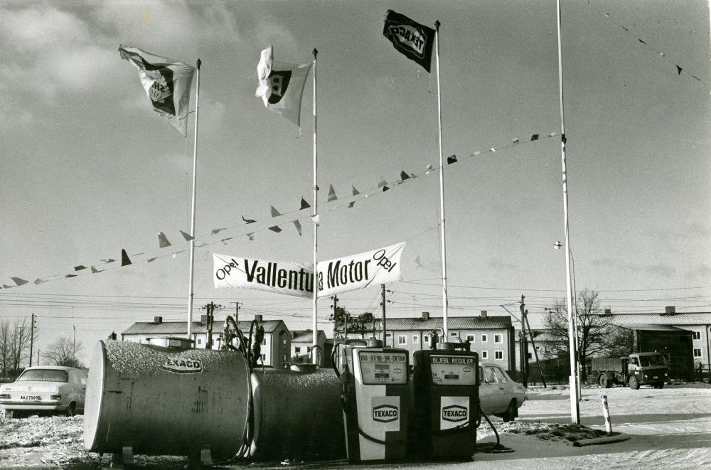 Texaco dieseltankar och pumpar vid bensinstationen Vallentuna Motor. Flaggor och flaggspel, Shell, BP, Texaco.

•Fotografiet ingår i bildserien ”Vardagsliv i Vallentuna kommun” av Rachael Gough-Azmier & Gunilla Blomé, Haga Studios HB.