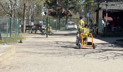 Barn cyklar i Kårsta utemiljö.