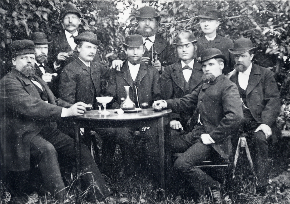 Lantbruksmöte (osäkert) Fr v Karl Jansson Bygget, Ville Jansson Bygget, Herman Forsberg Friberga, Severin Åkerberg Lundby, okänd, okänd, Karlsson Prästgården, Herman Gustavsson Borresta, och Amadeus Viberg Förmodligen dricker herrarna punsch, alla fint klädda med hatt. Ett namn saknas, osäkert vem som är vem