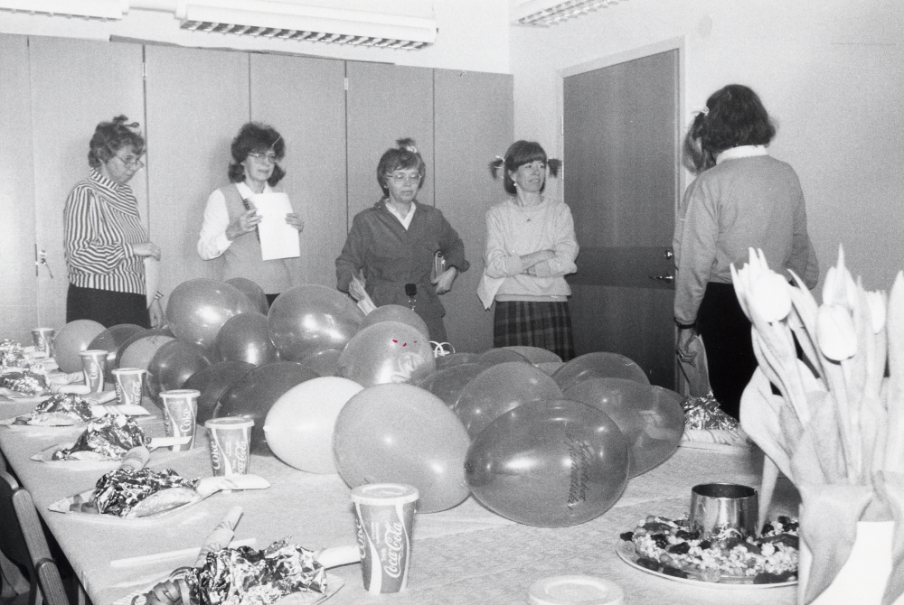 Lena Lundgren  på  Vallentuna bibliotek  har fyllt 40 år och skall firas av arbetskamraterna i biblioteks allrum. Det blir barnkalas med hamburgare, milk-shake och godistårta gjord av sega råttor och kamraterna har rosetter i håret. Fr v  Christina Jirstedt, Ulla-Britt Kvarnestam, Lena Wallén, Pirkko Mickelsson  skymd och okänd person samt Ulla Mörk