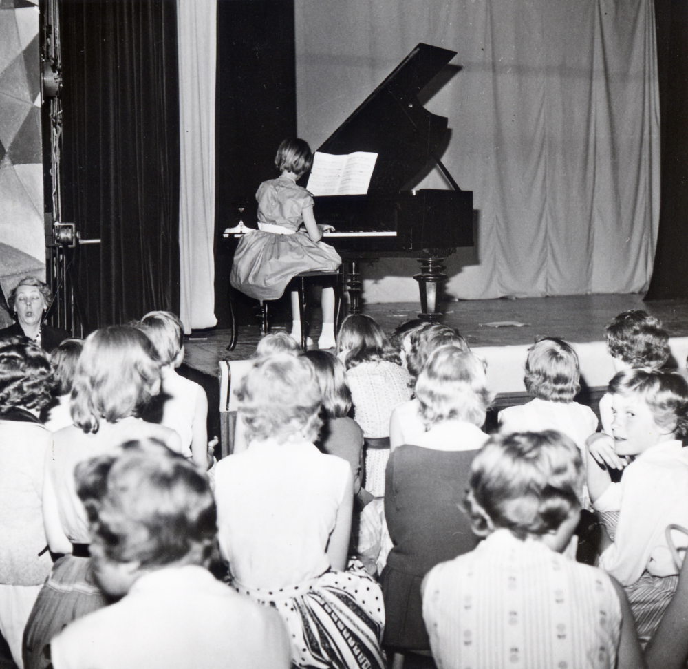 Musikuppvisning  i  Hjälmstaskolans aula  En flicka spelar på  flygeln