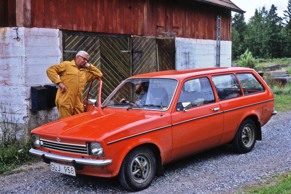 En arbetsdag med lantbrevbärare Mikael Mattsson. Lantbrevbäring på Hyddan; Lantbrevbärare Mikael Mattsson (i bilen) talar med Ivar Bergström på Hyddan. Bergstöm hade vinteruppställningsplats för bilar och husvagnar bakom byggnaden på bilden.