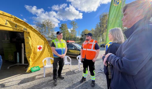 Gult tält med rött kors, människor i varselvästar framför.