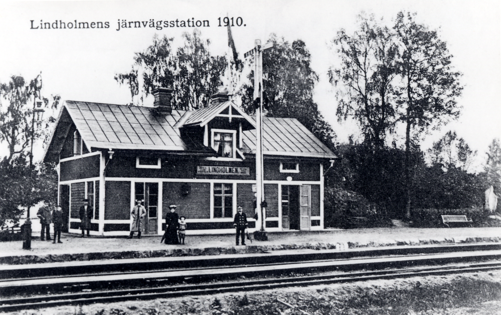 Framför stationshuset finns en semafor . På perrongen finns stationspersonal och civilklädda personer. Längst till höger syns Gustav Vasa-stenen.
