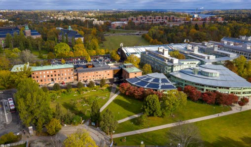 Bild på Stockholms universitet från ovan med närliggande omgivning av natur och bostäder.
