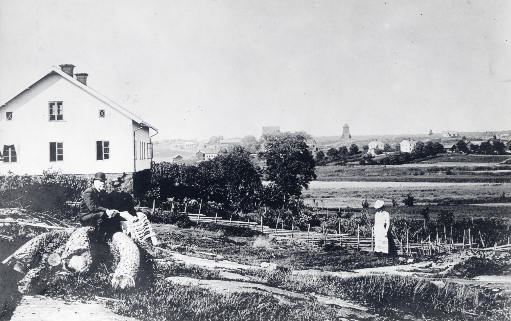 Össeby-Garns prästgård. På stenen sitter kyrkoherde Karl Hedén och hans hustru Ella. T h står Signe Pettersson senare gift Lundquist