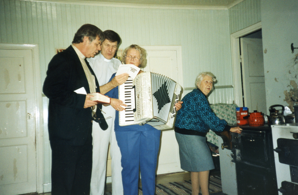Rosa Bergqvist fyller 90 år och blir uppvaktad med musik av fr v kyrkoherde Tom Wallgren, komminister Sören Stadell och hans fru Vivianne i huset i Gunby.  Rosa själv står vid vedspisen.  Se dokumentärfilmen "Hugo och Rosa" där filmaren Bengt Jägerskog följer Rosa och hennes bror Hugo under tio år.  De bodde i Gunby utan elektricitet eller telefon till några år innan de flyttade till Väsbygården strax före Hugos 100-årsdag.  Både Rosa och Hugo avled 2001.