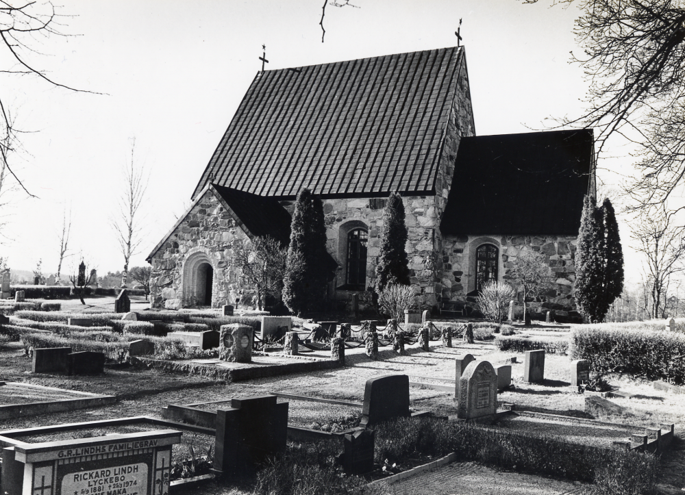 Össeby-Garns kyrka med kyrkogården i förgrunden