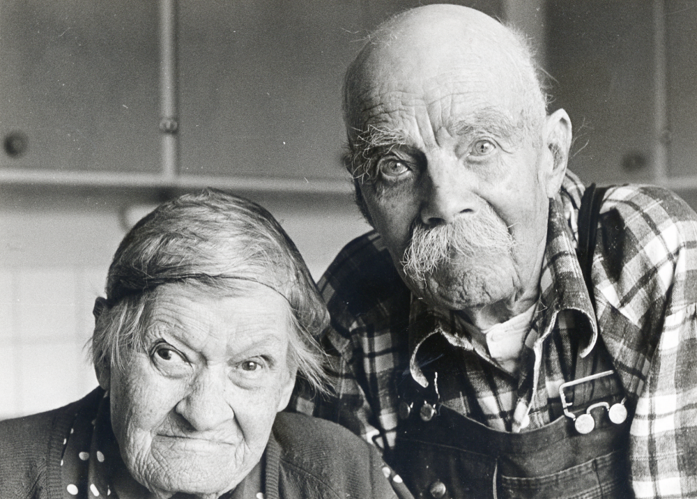 Tegelbruksarbetaren   Carl Johan Pettersson "Brännarpelle" och hans hustru  Anna Pettersson  90 år i sin bostad Norrgården 30..  De gifte sig den 25 oktober 1903 och hade varit gifta i 70 år när bilden togs.  Carl Johan Pettersson,   "Brännarpelle" var i många år brännare vid  Åby tegelbruk  och kommunal- och facklig förtroendeman. Född 23 september 1877 var han Vallentunas äldste invånare när kortet togs.  Han var erbjuden att flytta till Väsbygården, men ville bo kvar i sin lägenhet där han dog 1975.  Hans hustru  Anna Pettersson  född 1882, dog i januari 1974.

2022-01-17 Uppgifter från Kyrkoarkiven: Paret hade döttrarna Svea född 1904, Linnéa 1908 och Ingrid 1910.
2021-07-08 Uppgifter från svenskagravar.se: Pettersson, Karl Johan levde 1877-09-23 till 1975-06-19. Gravsatt: 1975-06-28 Vallentuna kyrkogård. Pettersson, Anna Maria levde 1882-12-15 till 1974-01-27. Gravsatt: 1974-02-09 Vallentuna kyrkogård