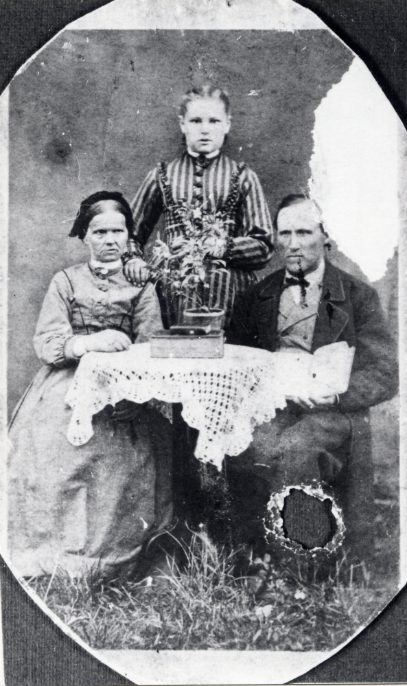 Möbelsnickare och byggmästare Carl Henrik Liljeblad med hustrun Lovisa Jansdotter Liljeblad samt troligen en av döttrarna (okänt vem). Paret var bland de fyra första som lät döpa sig bland baptisterna i Kårsta 1858. Baptistdop genomfördes i och med att konventikelplakatet hade upphävts det året. Liljeblad var med och byggde Björkholmens baptiskapell. Fotografiet är skadat med kulhål, förorsakat i samband med ett inbrott långt senare hos en av Liljeblads efterlevande släktingar. De två andra som döptes 1858 var P J Johansson och hans hustru Sofia. Carl Henrik Liljeblad dog 1911, hustrun Lovisa (av gammal Kårsta-släkt) 1881. Liljeblads bodde i Lovisedal i Kårsta, mittemot Björkholmens baptistkapell. Paret är morfars mormor och morfar till Börje Sjöman. 