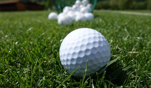 Golfboll i grönt gräs