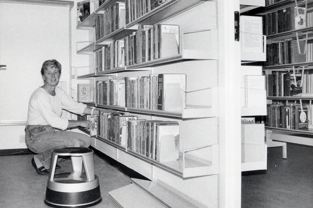 Karby bibliotek har reparerats sommaren 1987 och skall invigas med öppet hus 25 oktober. Vartefter hyllorna sätts upp, plockas böckerna in i hyllorna igen. Gunvor Svensson sätter upp ungdomsböcker i den nya barn- och ungdomsavdelningen