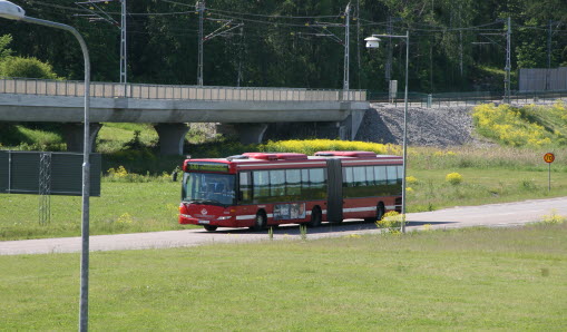 Röd buss som kör längs med vägen.