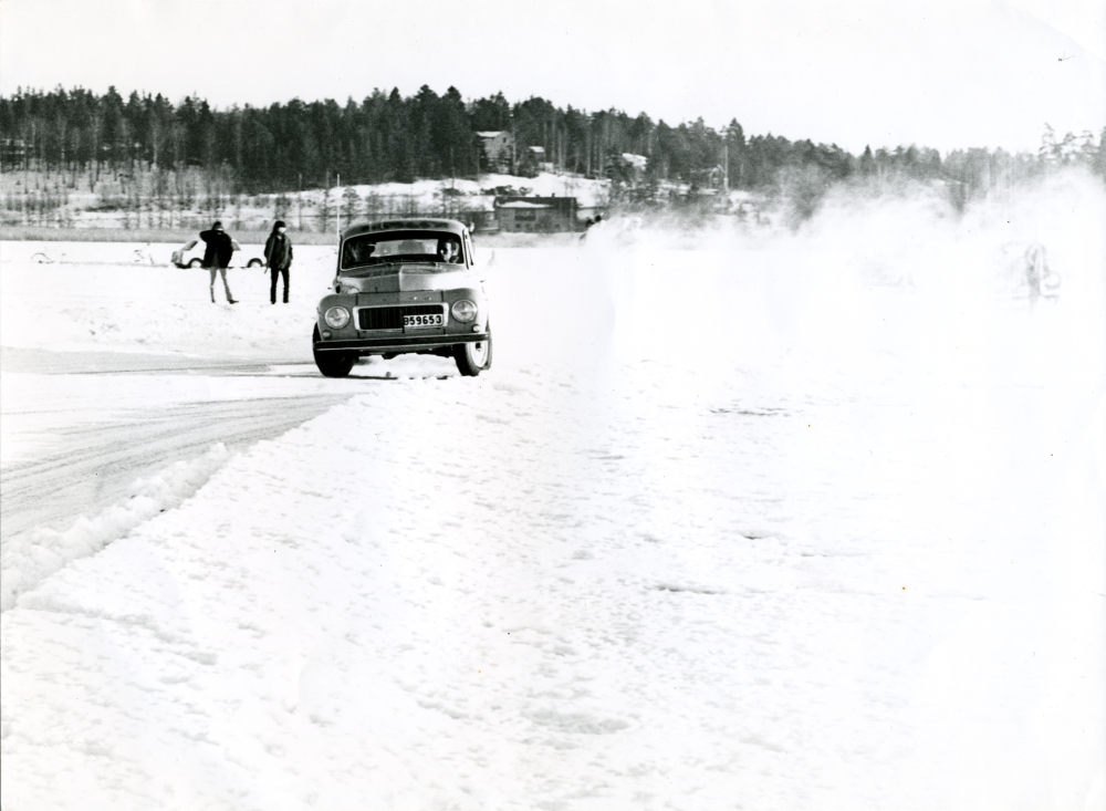 Den sjunde mars 1965 pågår en biltävling på Vallentunasjöns is. I bakgrunden syns pumpstationen och Stockholmsvägen.

Original och uppgifter Elisabeth Feldt