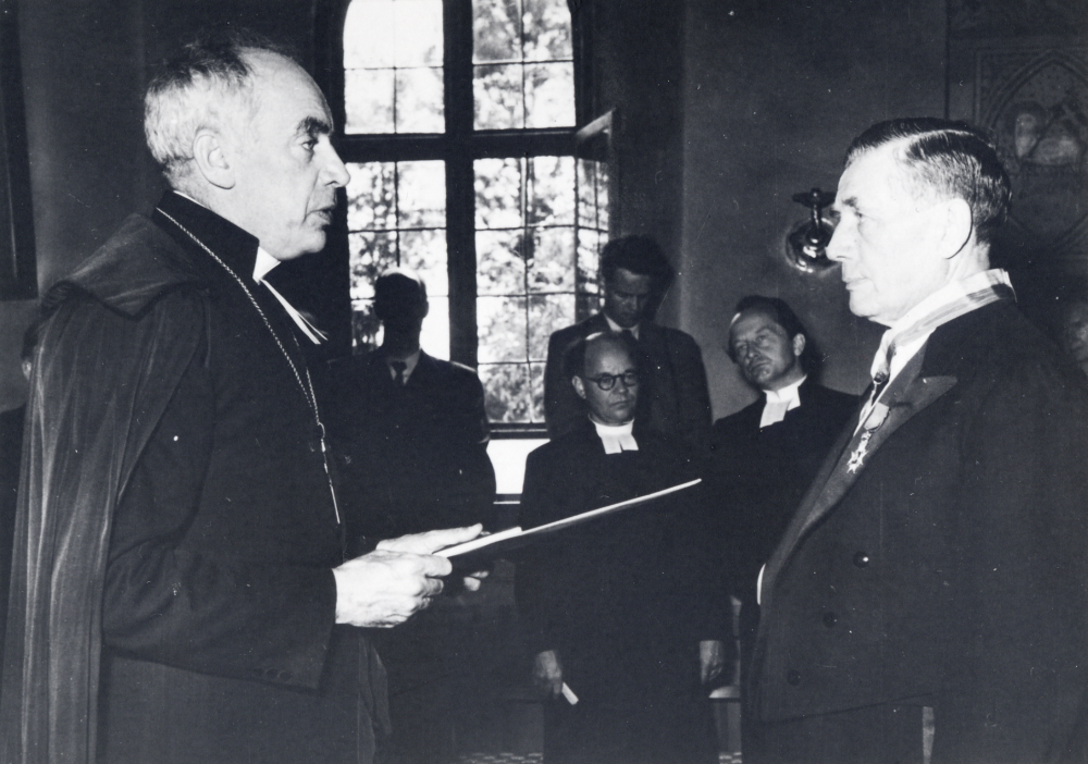 Biskop Manfred Björkqvist delar ut en medalj till Edvard Thorell, Stolp-Ekeby i Frösunda kyrka i samband med invigningen av Frösunda gravkapell, vilket Thorell skänkt till församlingen.