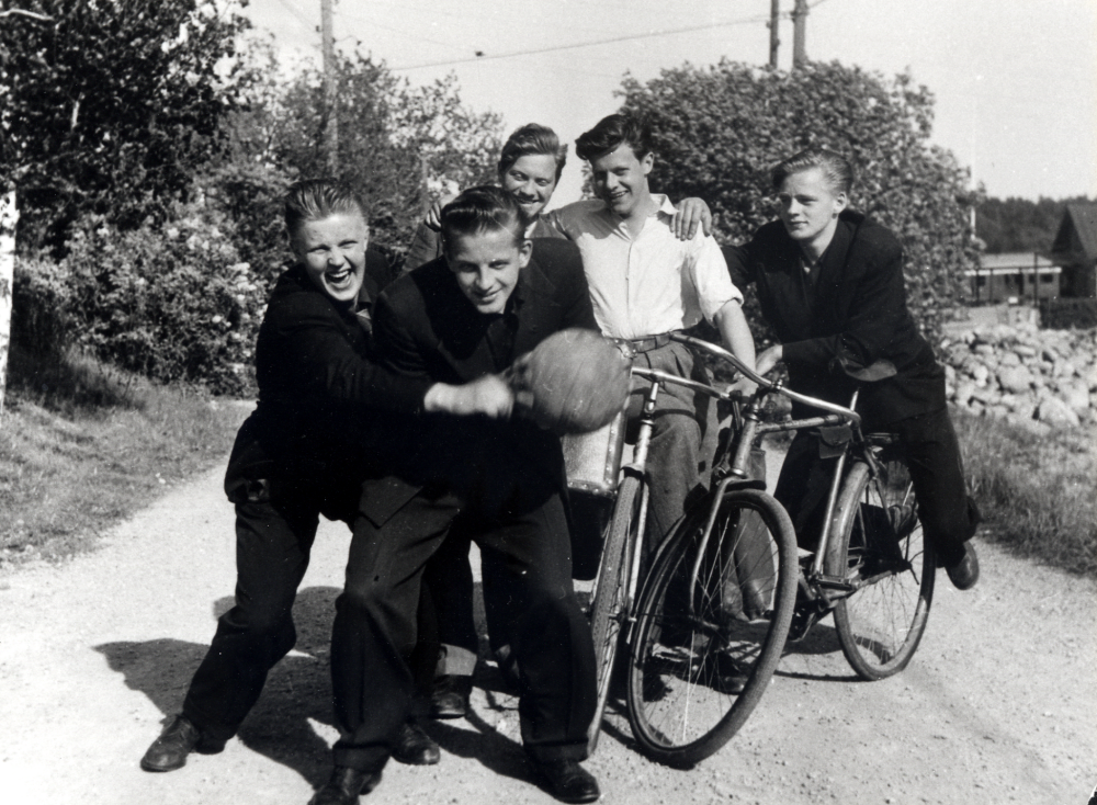 Ett gäng grabbar ur VBK utanför Vetebageriet på Allévägen i Vallentuna.  Killarna är troligen på väg hem till Tillborgs för att äta!  Fr v Olle "Bull" Andersson, Lars "Platt-Lasse" Larsson (ändrade senare efternamn till Liverhall), Karl "Stämmis" Karlsson, Åke Tillborg och Stig Österberg