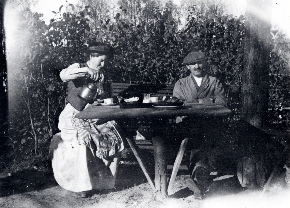 Kaffestund på Davidsborg i Trekanten. Mina Öberg häller upp kaffe, bredvid sitter maken Erik Öberg.
Uppgift om fotoår saknas, men troligen första delen av 1900-talet.