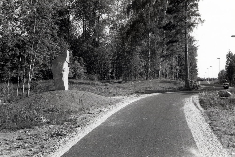 Ny gång- och cykelväg har byggts mellan Veda och Lindholmen.  En gång- och cykelväg fanns redan tidigare mellan Vallentuna och Veda.  Markarbetena har gjorts av grävmaskinist Alf Mickelsson, som också funnit och rest "bautastenen" öster om vägen.  På marken vid cyklarna sitter Magnus Hillbo