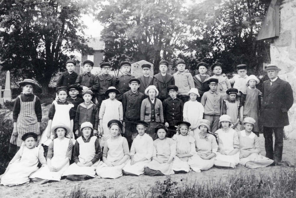 Lärare Fritiof Sundell tillsammans med skolbarnen från Kårsta kyrkskola samlade vid Kårsta kyrka. Bakre raden fr v Johan från Sunnarby, Sven Sandström, Erik Jansson, Sven Karlsson, Gösta Sundberg, Josef Gustavsson, Helge Davidsson, Ruben Gustavsson, Nisse Davidsson och Gösta Lindkvist. Mellan raden fr v Thyra Karlsson, Rut Djupström, Erik Gustavsson, Lisa Sandström, Karin Balck, Sigfrid Augustsson, Thyra Karlsson, Knut Andersson, Märta Viman, Erik Hellman, Karin Bergström och Ingrid Lundberg. Nedersta raden Svea Karlsson, Thyra Andersson, Elsa Eriksson, Nanny Johansson, Anna Hellman, Astrid Törnkvist, Sakarina Salström, Elvan Sundkvist, Gertrud Lundberg, Lilly Andersson och Fritiof Sundell, läraren