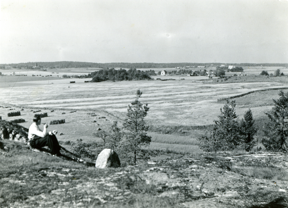 Herbert Holm sitter och röker med utsikt över Markimslätten.
