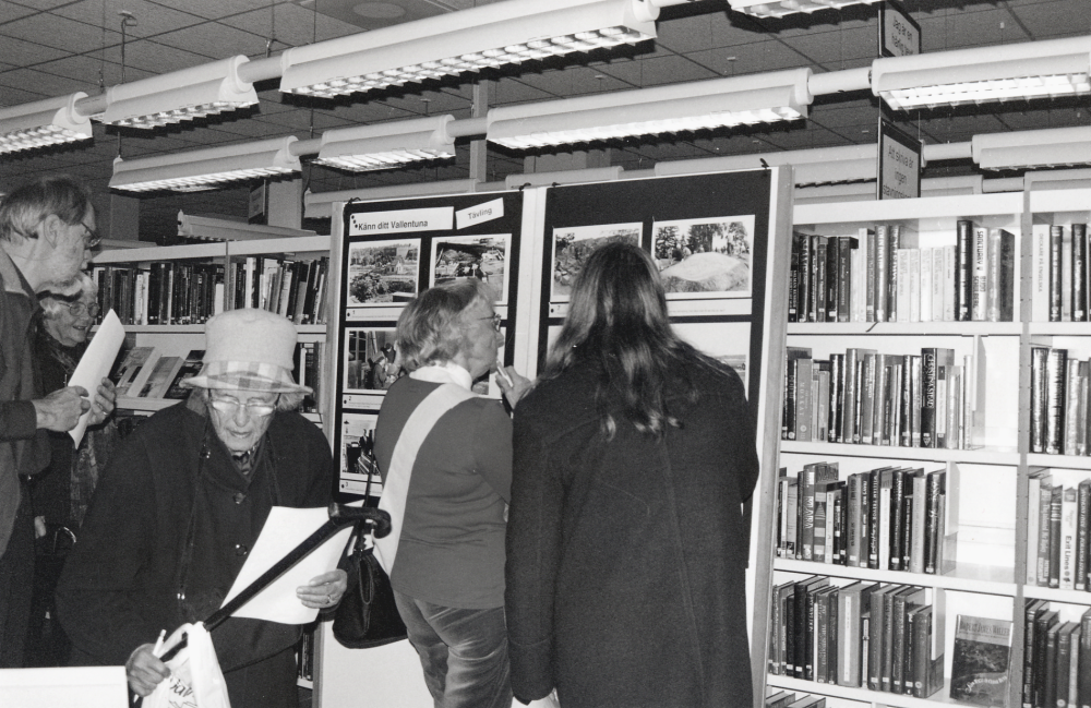 Bokfest 2003 med tema Berätta berätta - i toner, gester och ord! i samarbete med Vallentuna biblioteks vänener.  Vid Bildarkivets tävling Känn ditt Vallentuna, samlas många besökare.  Fr v står ev Alf Sigling, Britta Lugn, Anna-Lisa Gustavsson, Siv Jonsson och okänd med ryggen mot kameran
