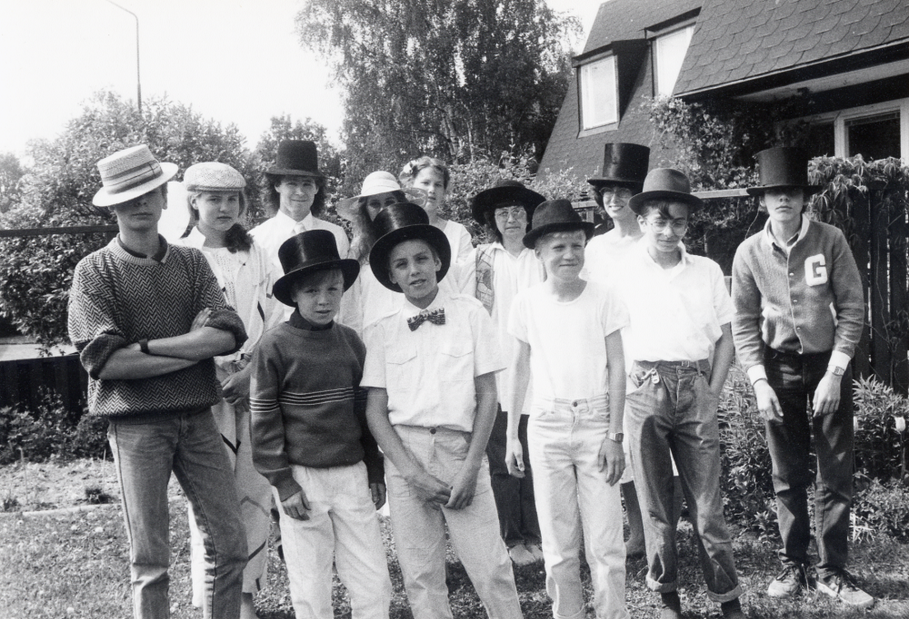 Examensdag den 4 juni 1985 med tårtfest hos familjen Rahmqvist på Bällstavägen 59 C i Bällsta.  Dagen firas med hattparad och fotografering.  Bakre raden fr v Brita Liljeqvist, Martin von Schmalensee, Hedvig Rahmqvist, Theräse Heidrich, Monica Westberg och Eva Rahmqvist. Främre raden fr v Magnus Hillbo, Henrik Johansson, Calle Rahmqvist, Håkan Pettersson, Tomas Westberg och Mikael Hillbo.  Barnen går i olika klasser och olika skolor, men känner varandra i olika relationer, familjen Rahmqvist är den förmedlande länken