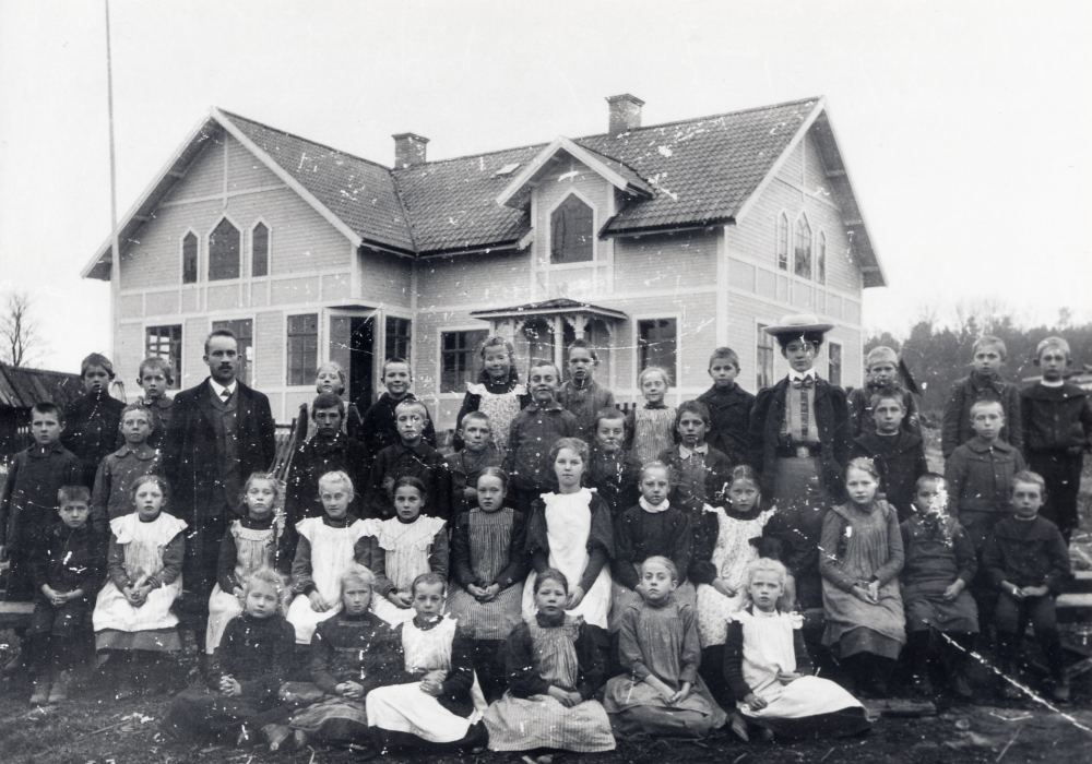Lärarna Brynolf Fromm och Britta Lindblom med skolbarnen utanför Vada skola. I översta raden nr fr v v står Helmer Johansson, nr fr h är Gösta Eneroth