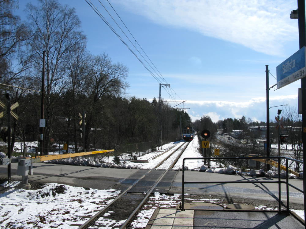 Ett tåg är på väg in till perrongen vid Bällsta järnvägshållplats.