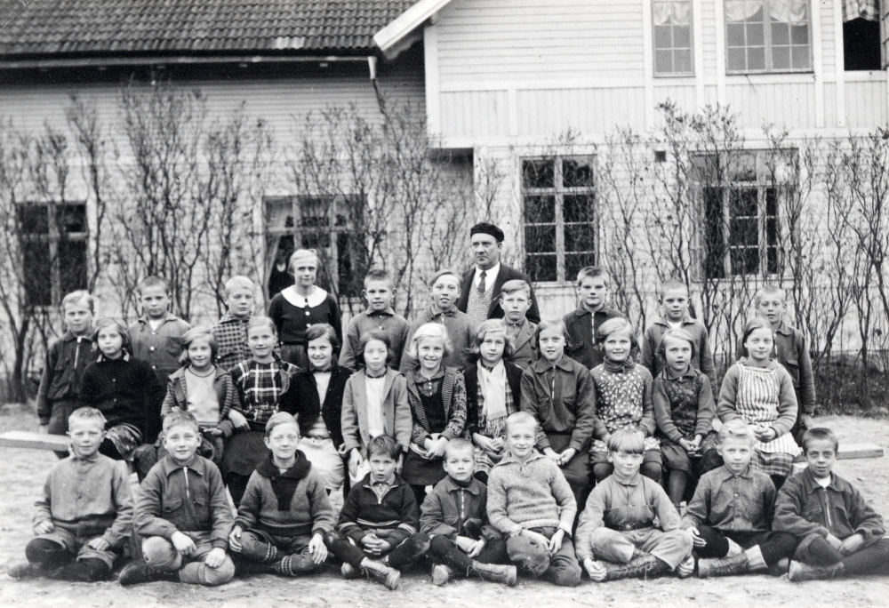 Lärarinnan Olga Pettersson och läraren Brynolf Fromm tillsammans med barnen utanför Vada skola, byggd 1905.