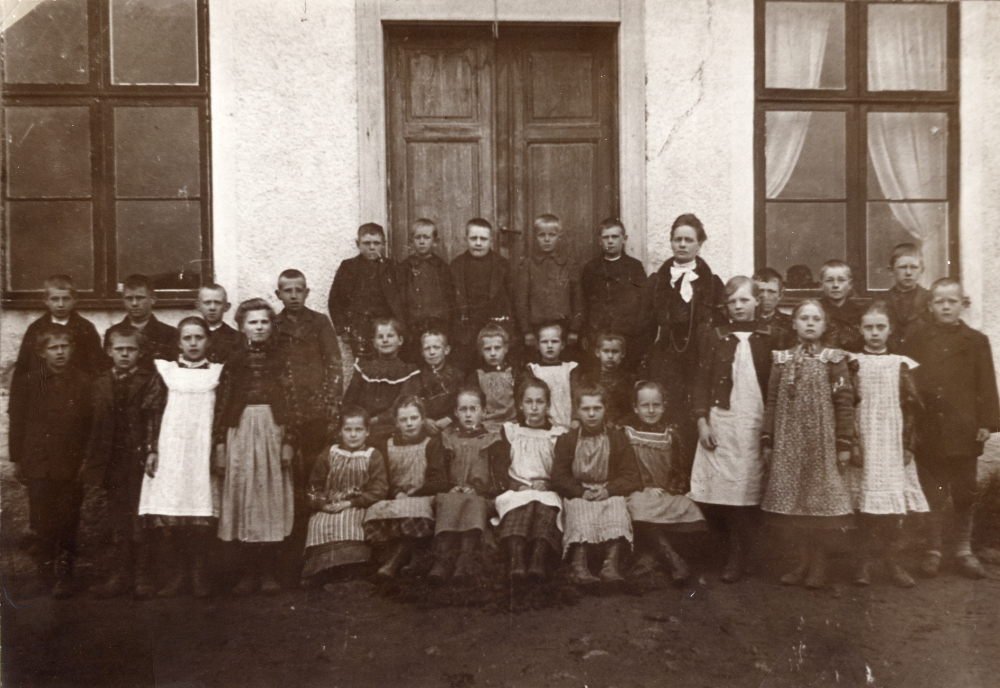Lärarinnan Mariana Nordenmark tillsammans med skolbarnen framför Berga skola. Fröken Nordenmark tjänstgjorde ca 35 år vid Berga skola