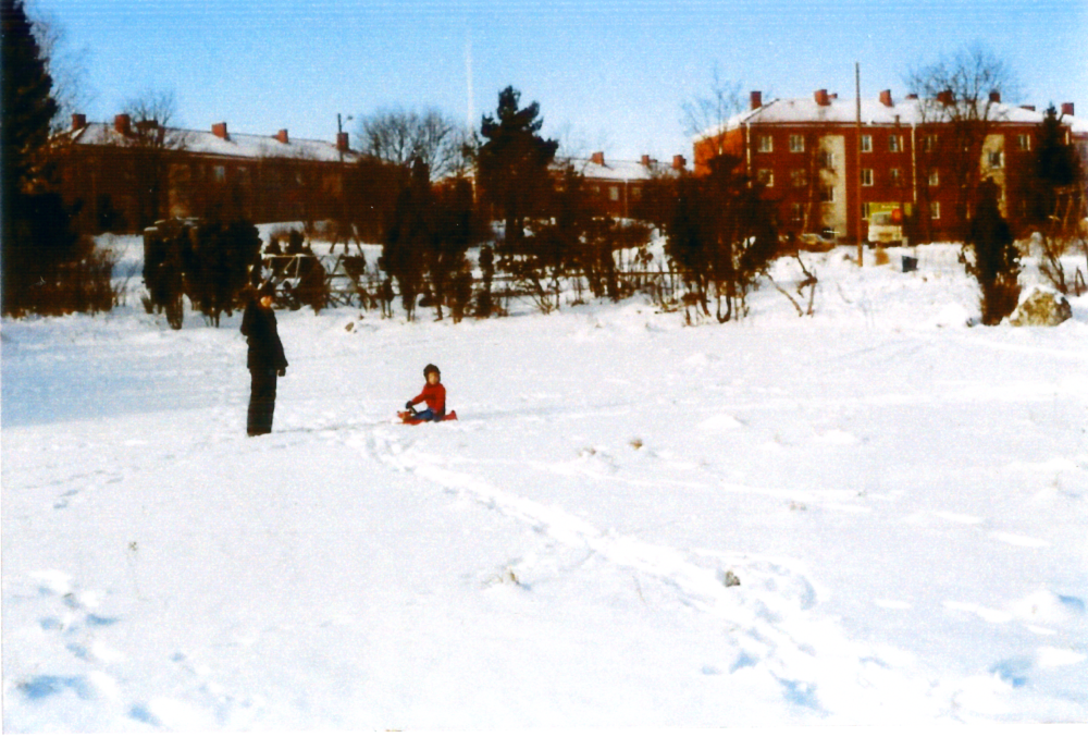 På tomten Rickeby 1:152 kommer så småningom Pingskyrkan, idag Centrumkyrkan, att byggas. I bakgrunden syns flerbostadshusen vid Rickebyhöjd. Personerna är okända. Vinterbild.