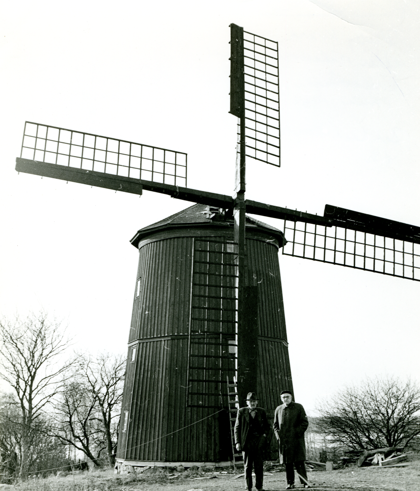 Framför kvarnen står t h Bernhard Bengtsson och eventuellt Einar Levander som byggde vingarna. Vingarna invigdes i maj 1968, men glädjen blev kortvarig då de blåste sönder under höststormen i Allhelgonahelgen 1969.