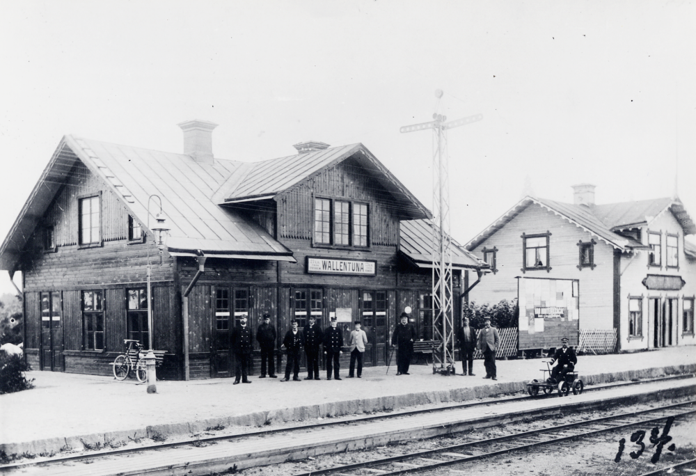 Vallentuna järnvägsstation i början av seklet.  Framför stationshuset finns en  semafor. På spåret närmast stationshuset finns en  dressin med en uniformsklädd man. 

På originalkortets baksida står antecknat: 1000 st å gravyrkartong platina.