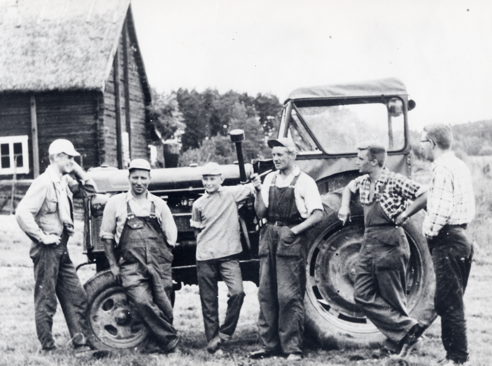 Samling runt traktorn på Oppgården. Fr v står Lars Wiberg, Gösta Grönberg, Jan-Olof Grönberg, gårdens ägare K G Jonsson, Paul Strömberg och Erik Mohlin. I bakgrunden syns ladugården med halmtak