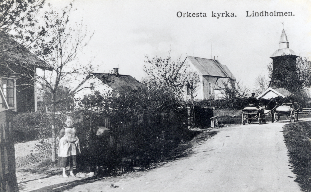 Orkesta kyrka.  Kopia av vykort poststämplat 8 februari 1912.  Fr v syns huset Sturehill, Småskolan och Orkesta kyrka.  Ev heter flickan Ahlgren, hennes farfar var skräddare och bodde i Sturehill. Två hästdragna vagnar passera kyrkan.  Från 1863-1884 var Carl August Sjögren klockare, organist och lärare i skolan. Byggde också en handelsbod invid kyrkan.  I denna lilla handelsbod inrymdes också posten, som Sjögren skötte 1875-1879