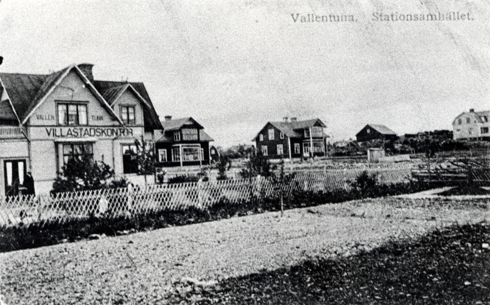 Del av Vallentuna stationssamhälle. T v Vallentuna villastadskontor AB Billiga tomter senare konditori, Jordbrukskassan och klädesaffär Kära barn . Huset revs i november 1982. T h syns de s k Tvillingvillorna eller Syskonvillorna den vänstra villan revs 1981 inför byggstarten av Tärningen