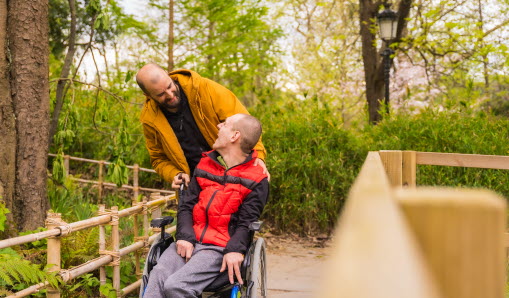 person i rullstol med assistent